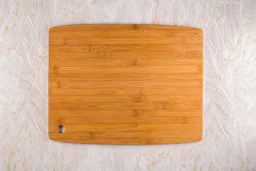 Wooden cutting board on a gray marble background