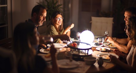 Beautiful family on dinner talking and smiling at terrace