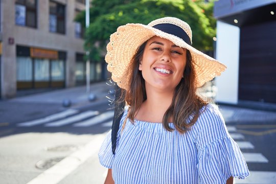 Young beautiful woman smiling happy walking on city streets on a sunny day of summer