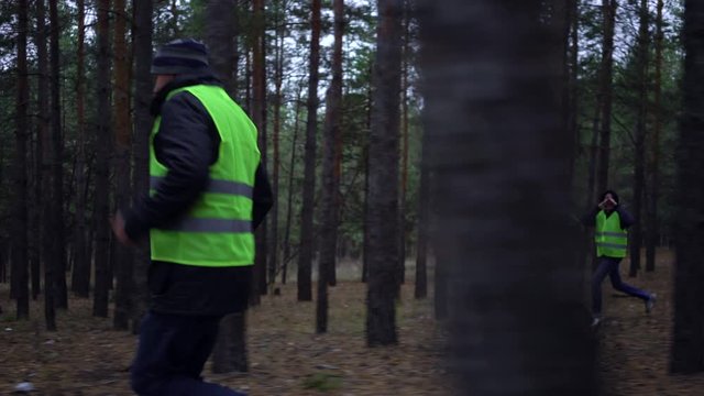 group of volunteers in green vests went in search of missing persons in a pine forest