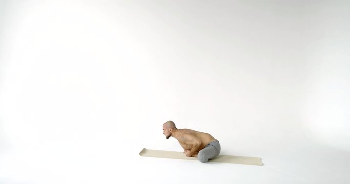 man in baddha konasana with bending over on mat slow motion