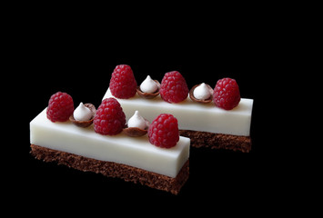 White mousse desserts with raspberries and meringues on brownie base