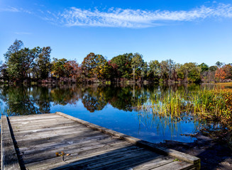 Small dock at Lake Erie with fall and autumn colored trees in the back ground 