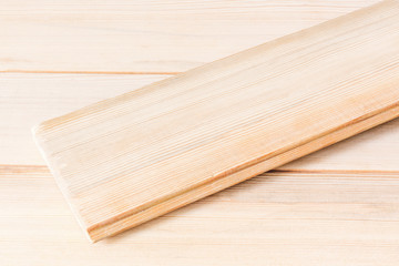Wooden polished boards with a latch for collecting surfaces. One board lies across the rest. Eco-friendly natural lumber