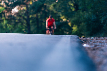 Tall handsome biker rides his bicycle on sunset in a lovely magical forest.