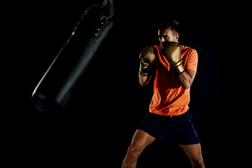 Fototapeta na wymiar Strength male boxer training with punching bag. Boxing exercise