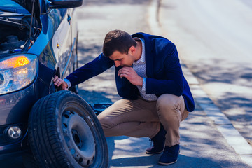 man in need of flat tire assistance
