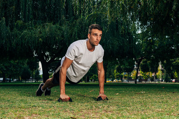Push up fit man doing arm workout exercising bodyweight exercise pushup outdoor in nature