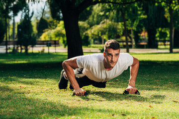 Front view portrait of concentrated, confident, sporty, athletic, attractive man making, showing push up position