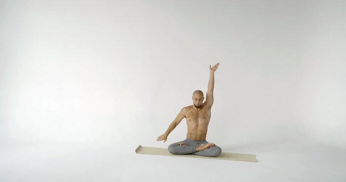 man bends over in gomukhasana pose from lotus slow motion