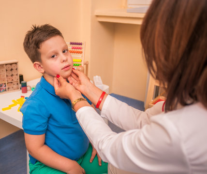 Female Pediatrician check's the throat and mouth of a young cute boy.