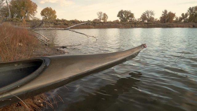Zoom on a bow of long, narrow racing sea kayak on a lake shore with light breeze, fall scenery in Colorado
