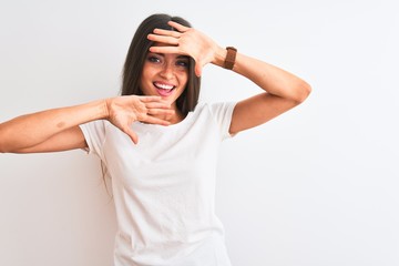 Young beautiful woman wearing casual t-shirt standing over isolated white background Smiling cheerful playing peek a boo with hands showing face. Surprised and exited