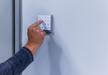 Man typing numbers on a white numeric keypad