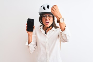 Young businesswoman wearing bike helmet holding smartphone over isolated white background annoyed and frustrated shouting with anger, crazy and yelling with raised hand, anger concept