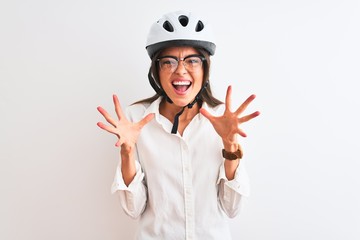 Beautiful businesswoman wearing glasses and bike helmet over isolated white background celebrating crazy and amazed for success with arms raised and open eyes screaming excited. Winner concept