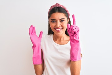 Young beautiful woman wearing clean gloves standing over isolated white background surprised with an idea or question pointing finger with happy face, number one