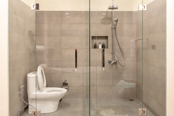 Modern bathroom interior with transparent glass partition.