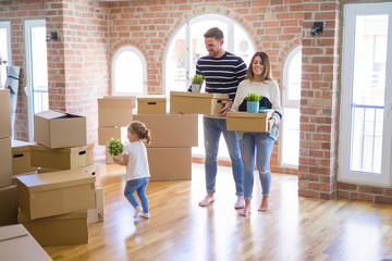 Beautiful famiily with kid moving cardboard boxes at new home