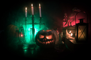 Halloween still-life background with different elements on dark toned foggy background. Selective focus