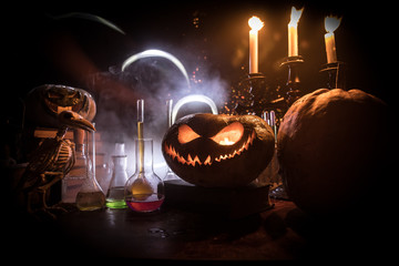 Halloween still-life background with different elements on dark toned foggy background. Selective focus