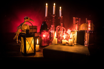 Halloween still-life background with different elements on dark toned foggy background. Selective focus