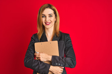 Fototapeta premium Young beautiful redhead businesswoman wearing suit holding flip board