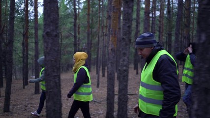group of volunteers in green vests went in search of missing persons in a pine forest