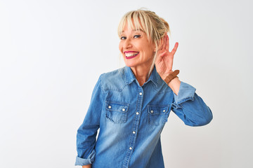 Middle age woman wearing casual denim shirt standing over isolated white background smiling with...