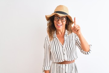Obraz na płótnie Canvas Middle age businesswoman wearing striped dress glasses hat over isolated white background surprised with an idea or question pointing finger with happy face, number one