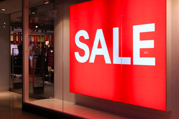 Window display with red sale board in night view