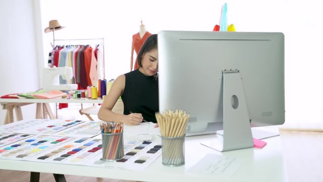 Young fashion designer sketching the new collection in modern studio. Designer working process