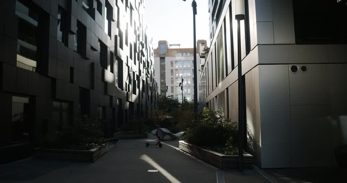 Cinema 4K gimbal medium wide shot with slide motion of dark building walls reflecting sunset light in the Barcode section of the new and popular Bj&oslash;rvika Opera quarter, in Oslo Norway.