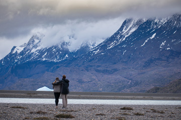 Couple Standing in Awe of Torres Del Paine Mountain Range and Glacier Grey in Patagonia Chile