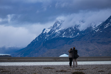 Couple Standing in Awe of Torres Del Paine Mountain Range and Glacier Grey during Winter in Patagonia Chile