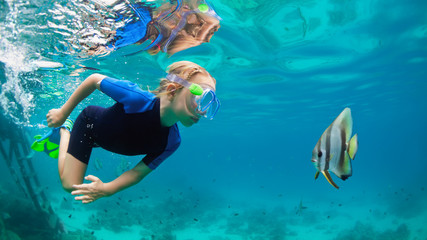Happy family - active kid in snorkeling mask dive underwater, see tropical fish Platax ( Batfish )...