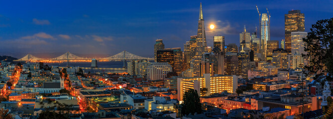 San Francisco skyline panorama at dusk with Bay Bridge and downtown skyline under a full moon