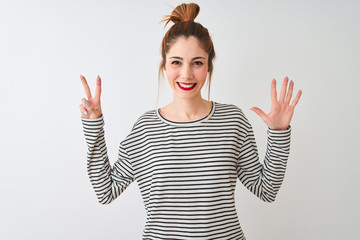 Redhead woman wearing navy striped t-shirt standing over isolated white background showing and pointing up with fingers number seven while smiling confident and happy.