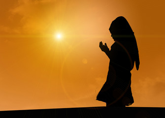 Silhouette of Women Muslim praying Faith with atmosphere In the evening sun Shine.