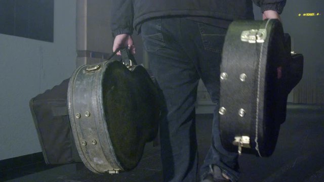 Roadie Musician Support Crew Member Carrying Heavy Guitar Boxes To Stage. Slowmotion