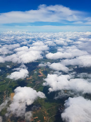 Beautiful clouds on the sky that can also see scenery of the ground. Cabin view from airplane.