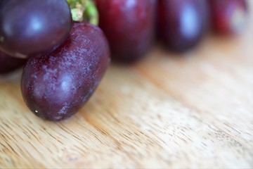 close up view on fresh red rapes on wooden table