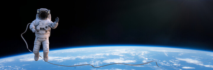 astronaut in spacesuit during spacewalk above planet Earth © dottedyeti