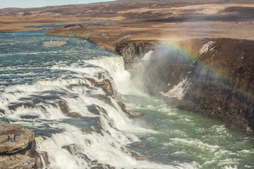 A rainbow over the three-step staircase of the Gullfoss waterfall on Hvita river in southern Iceland