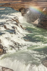 A rainbow over the three-step staircase of the Gullfoss waterfall on Hvita river in southern Iceland