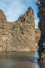 Basalt rock formations and lava columns and arches of Hjálparfoss waterfall (part of Fossá rivera) in south Iceland