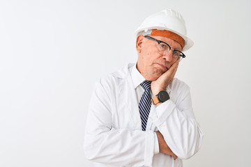 Senior grey-haired engineer man wearing coat and helmet over isolated white background thinking looking tired and bored with depression problems with crossed arms.
