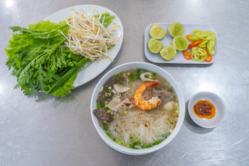 Vietnamese rice noodle soup and shrimp served with vegetables