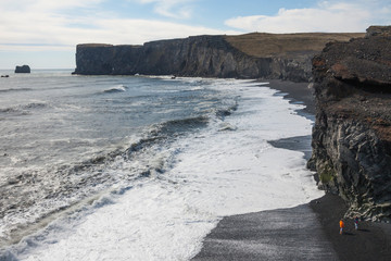 Reynisfjara black basalt sand beach in Vík í Mýrdal in Iceland on the west side of Mýrdalssandur glacial outwash plain as captured together with basalt columnar formations and cliffline
