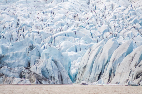 Tongue of the Breiðamerkurjökull glacier as it retreats into glacier lagoon Jökulsárlón leaving floating icebergs (Vatnajökull National Park in Iceland)